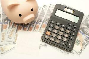 Piggy bank with calculator and notebooks on white background and copy space, financial goal concept. photo