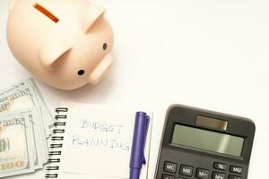 Money budget planning. Piggy bank with calculator and notebooks on white background, financial goal concept. photo