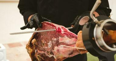 Banner of professional ham carver cutting cured ham slices. Spanish iberian ham. photo