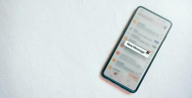 Banner of a smartphone with a new message notification on screen and white texture background. Communication business technology. Inbox view. New e-mail on mobile smartphone. photo