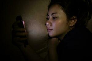 Closeup of asian women using smartphone at late night, Can't sleep. Sleep disorder concept. photo