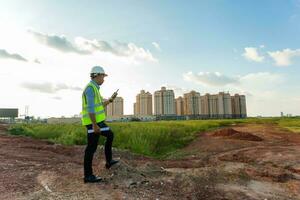 Engineer male use smartphone for working or checking at construction building site photo