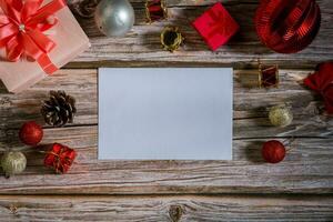 Navidad composición en un madera antecedentes y un blanco rojo tarjeta para escritura el texto. diseño Navidad antecedentes concepto foto