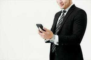 Business Asian man holding a fascicule with documents and using a smartphone for contact work in office on white background. photo