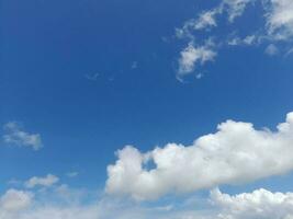 White clouds in the blue sky. Beautiful bright blue background. Light cloudy, good weather. Curly clouds on a sunny day. photo