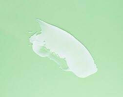 frotis de blanco crema para cara y cuerpo en un verde antecedentes foto