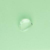 Drop of transparent face and body cream on a green background photo