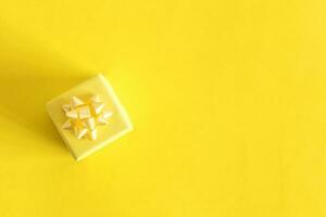 Top view of small yellow gift. Celebration concept. On pastel yellow background. photo