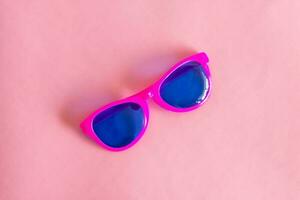 Top view of sun glasses. Summer concept. On pastel pink background. photo