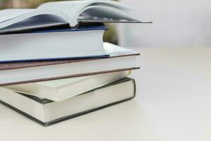 Desk with stack of study books. Textbooks for the student, university. Study from home. Distance education concept. photo