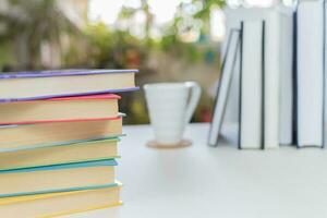 Desk with stack of study books. Textbooks for the student, university. Study from home. Distance education concept. photo