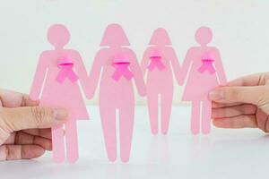 Breast Cancer Awareness, paper girl silhouettes and pink ribbon symbol. photo