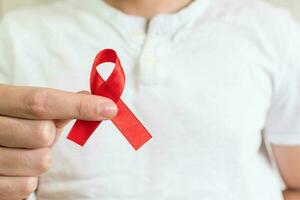 World Aids Day, hand with red ribbon symbol photo
