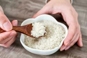 Close up of wooden spoon with rice grains. photo