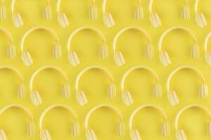Top view of pattern headphones on yellow background. Minimalist photo of pattern earphones. Yellow DJ headphones.