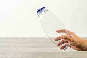 Female hand holding empty shampoo bottle. photo