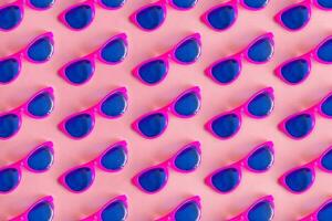 Top view of pattern sun glasses. Summer concept. On pastel pink background. photo