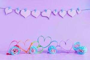 Love hearts with the colors of LGBT and roses on blue background. photo