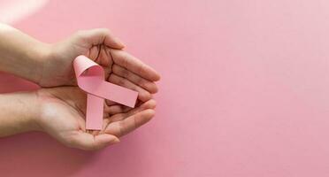 mujer manos participación rosado cinta, pecho cáncer conciencia. mundo cáncer día concepto. foto