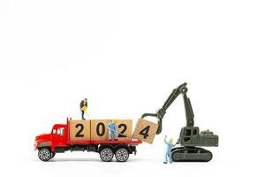 Miniature people , Worker team create a wooden block with the number 2024 photo
