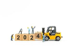 Miniature people , Worker team create a wooden block with the number 2024 photo