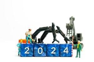 Miniature people , Worker team flips a block with the number 2024 photo