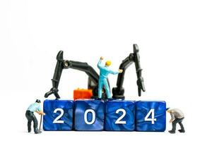 Miniature people , Worker team flips a block with the number 2024 photo