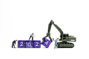 Miniature people , Worker team flips a block with the number 2024 photo