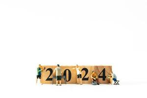 Miniature people , A joyful family enjoys New Year's celebrations with wooden block 2024 photo