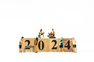 Miniature people , A joyful family enjoys New Year's celebrations with wooden block 2024 photo