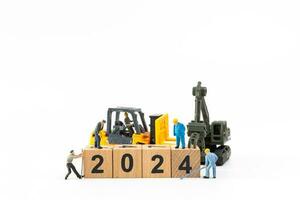 Miniature people , Worker team create a wooden block with the number 2024 photo