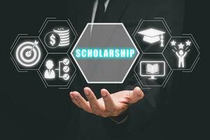 Scholarship concept, Person hand holding scholarship icon on virtual screen. photo