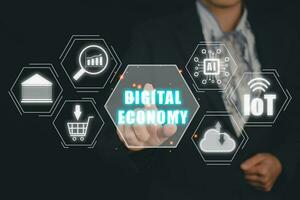 Digital economy concept, Person hand touching digital economy icon on virtual screen. photo