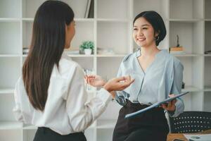 Female operations manager holds meeting presentation for a team of economists. Asian woman uses business paper with Growth Analysis, Charts, Statistics and Data. photo