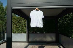 White T-shirt hanging on a hanger, layout photo