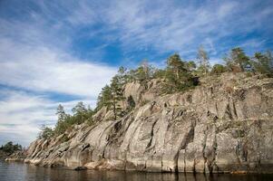 escarpado acantilados en ladoga skerries granito isla de sortavaly en verano debajo un azul cielo foto