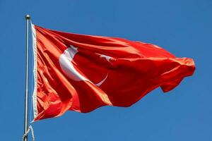 Waving Turkish flag. Sky background. Flag with star and crescent symbol photo