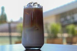 Iced coffee in glass cup or coffee latte on blurred background photo