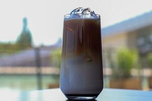 Iced coffee in glass cup or coffee latte on blurred background photo