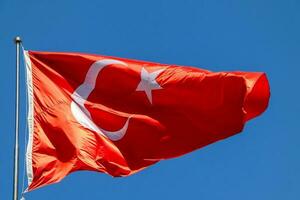 Waving Turkish flag. Sky background. Flag with star and crescent symbol photo