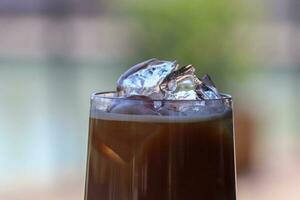 Iced coffee in glass cup or coffee latte on blurred background photo