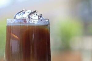 Iced coffee in glass cup or coffee latte on blurred background photo