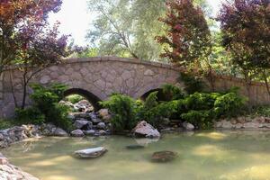 Scenery of Old Pack Horse Bridge over calm river under cloudy sky photo