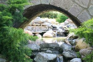 Scenery of Old Pack Horse Bridge over calm river under cloudy sky photo