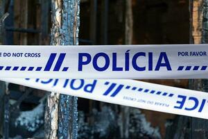 Portuguese police tape barricading a burnt house photo