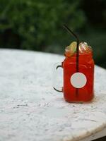 Red lemon soda water flavoured drink, Cool Drinks Beverages with ice in clear glass on white table photo