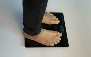 standing on the indoor scales There is space for text. The problem of being overweight or underweight photo