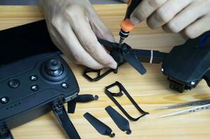 Professional mechanic repairing a drone with a small screwdriver on the table with various tools in modern workshop photo