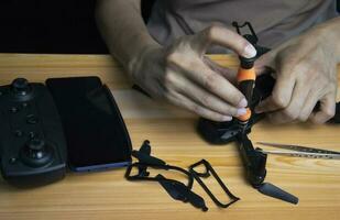 Repairing a small screwdriver drone on the table with various tools in modern workshop photo