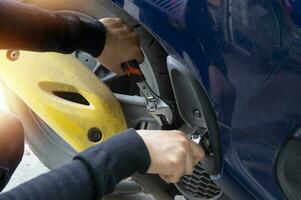 Woman fixing a motorcycle with a wrench photo